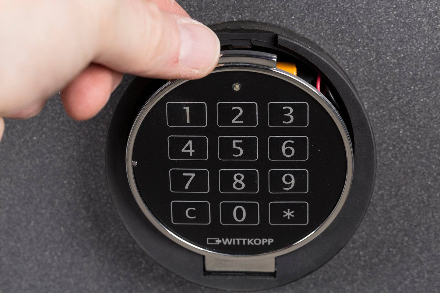 Hand accessing battery compartment of De Raat DRS Vega 45 electronic lock, part of the S2 rated 42L security safe.