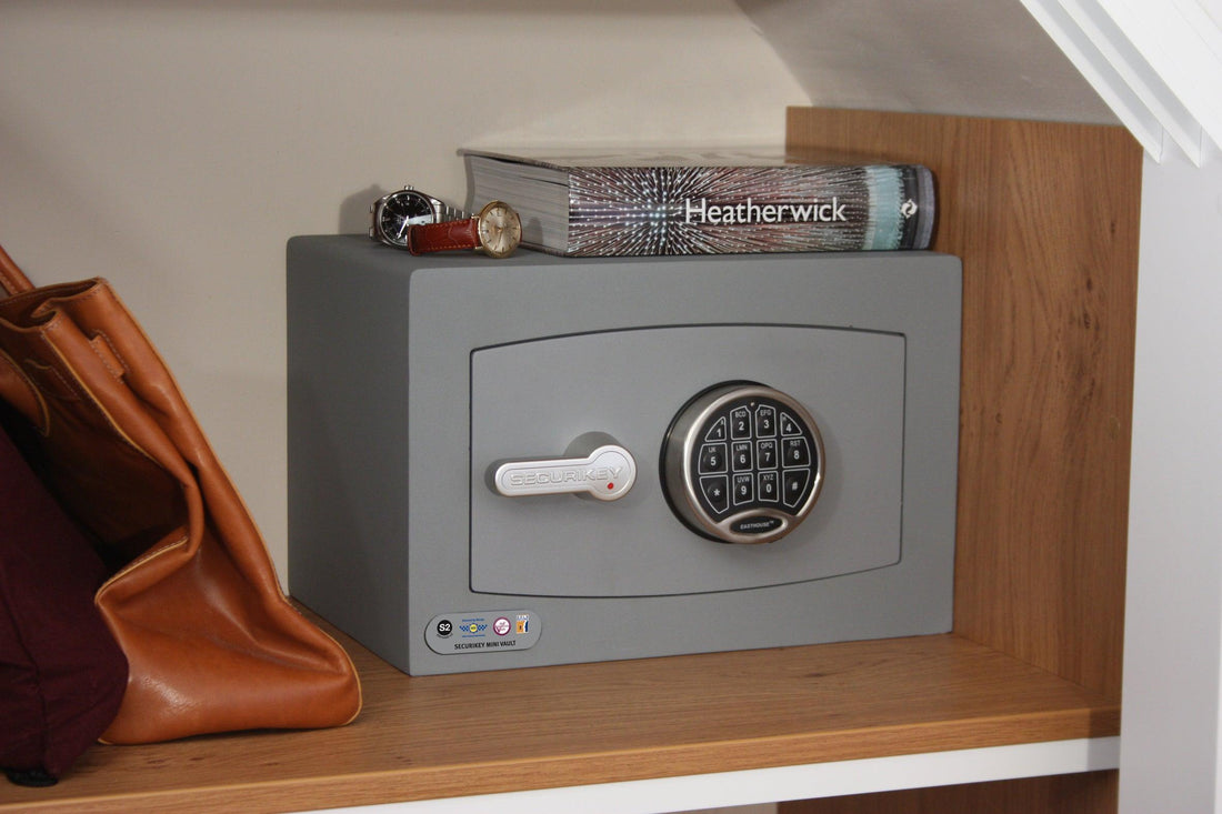 Secure home safe with digital keypad on wooden shelf.